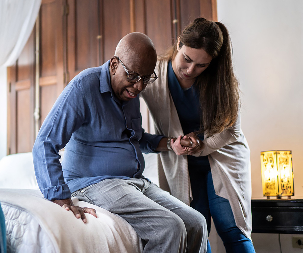 black senior patient assist by caregiver