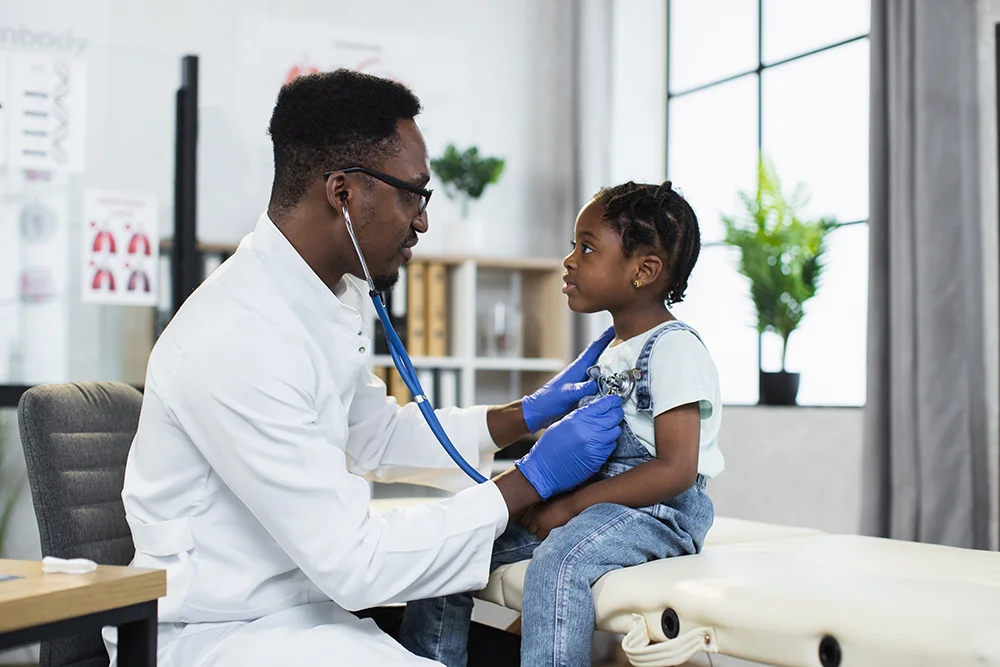 little black girl check her heart by a doctor